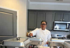 African American chef plating Southern food in a cozy kitchen setting, showcasing soul food traditions.